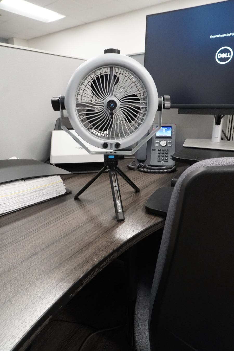 MistOne on a tripod beside an office monitor.