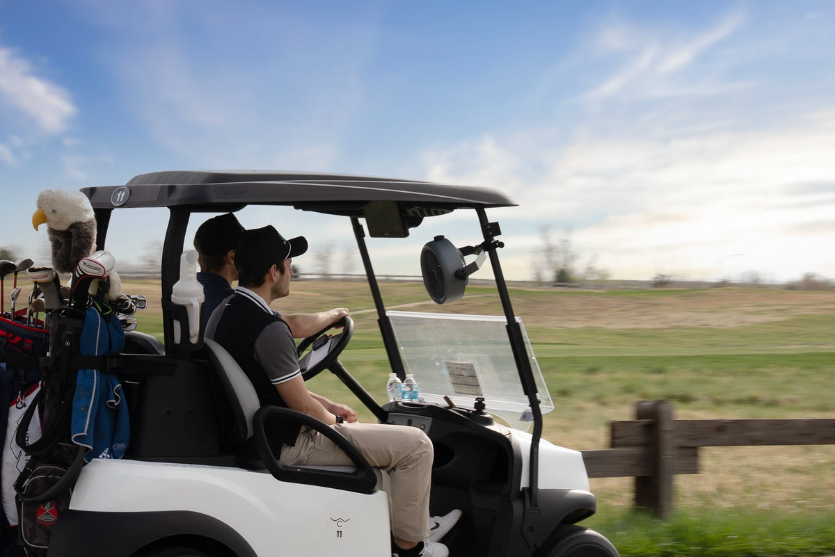 Zefra MistOne fan clamped to a golf cart roof support beside the driver.