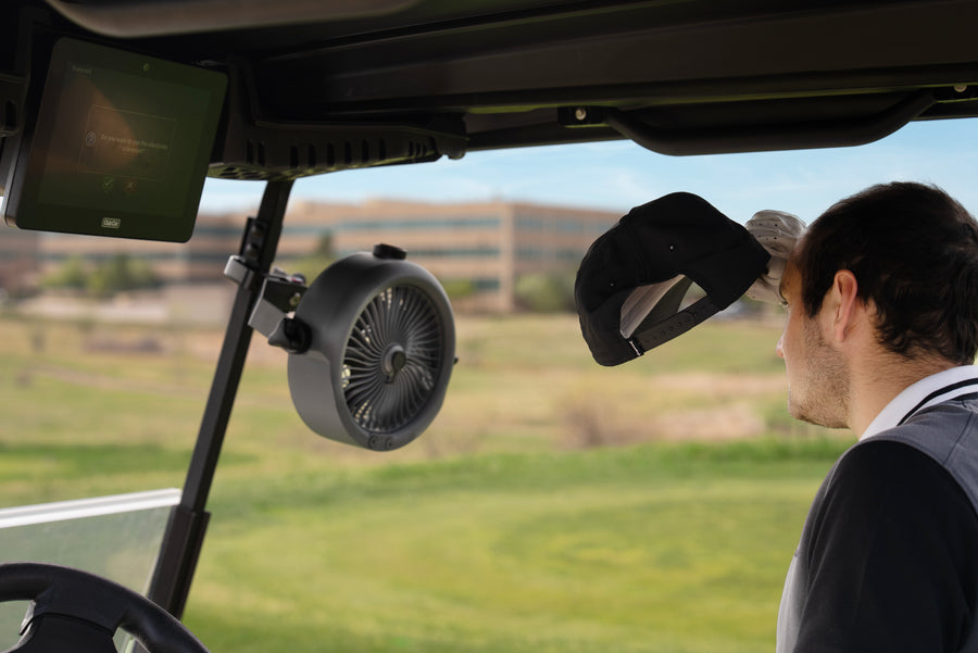 MistOne mounted inside a golf cart beside a golfer.